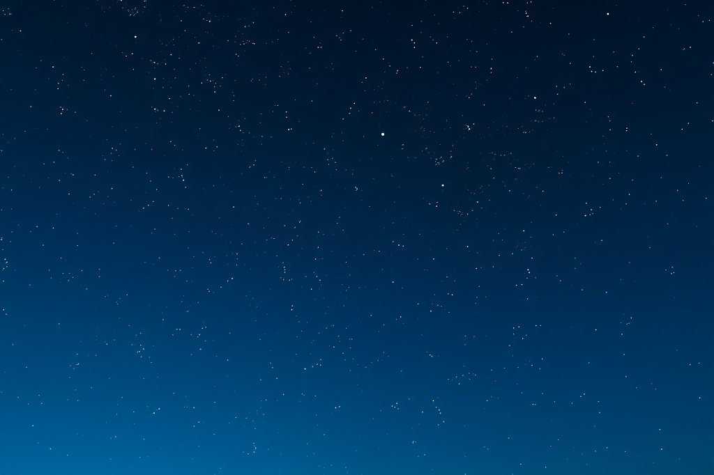 Cielo nocturno estrellado sobre siluetas del desierto